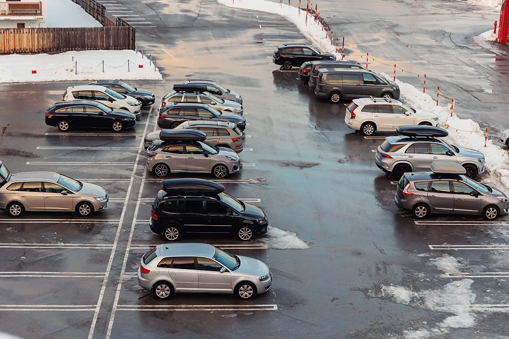 Parkplatz mit Schneeverwehungen in der Nähe des Flughafenterminals