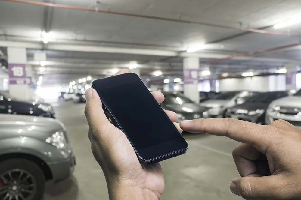 Hand eines Mannes, der ein Smartphone hält. Parkplatz Hand eines Mannes, der ein Smartphone hält. Parkplatz